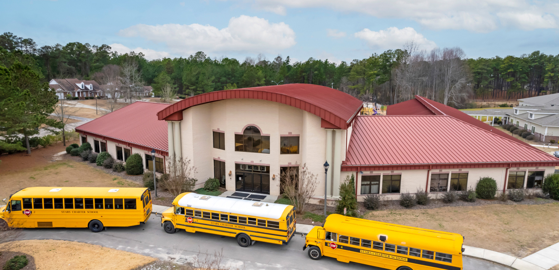Yellow buses lined up in front of large school building
