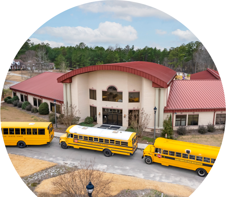 Yellow buses lined up in front of newly built school