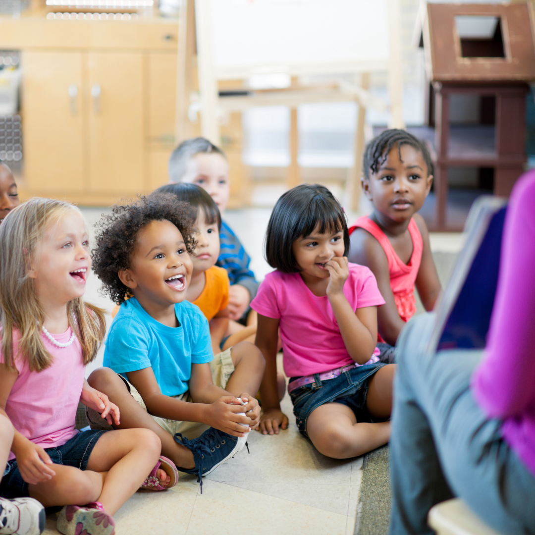 Students listening to a teacher read in class.