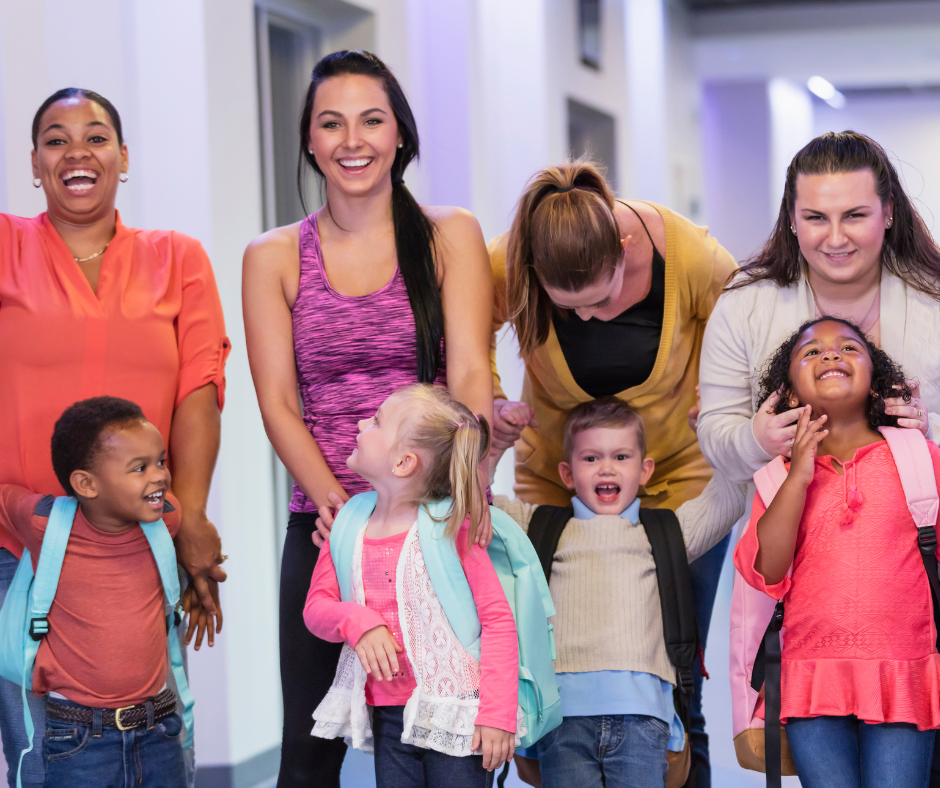 4 adults stand behind 4 children 