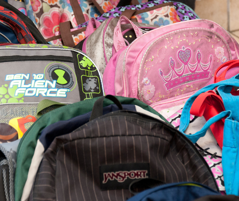 brightly colored backpacks stacked up together