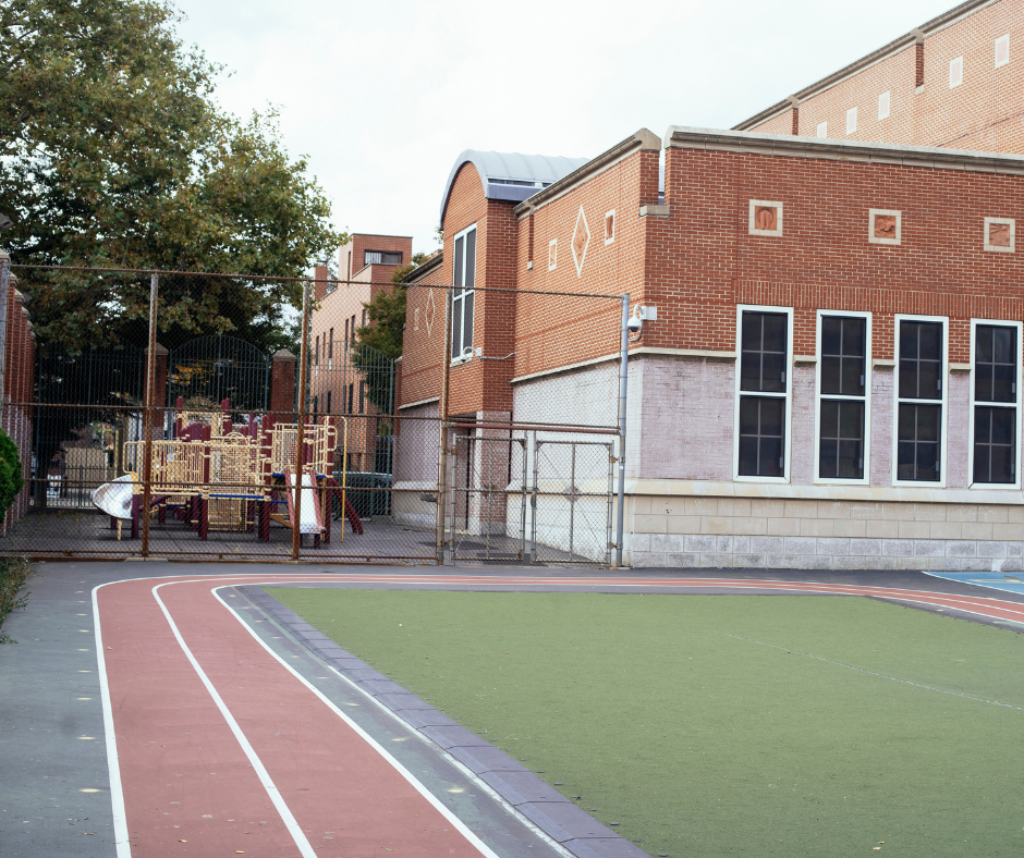 exterior of a school building and red painted track