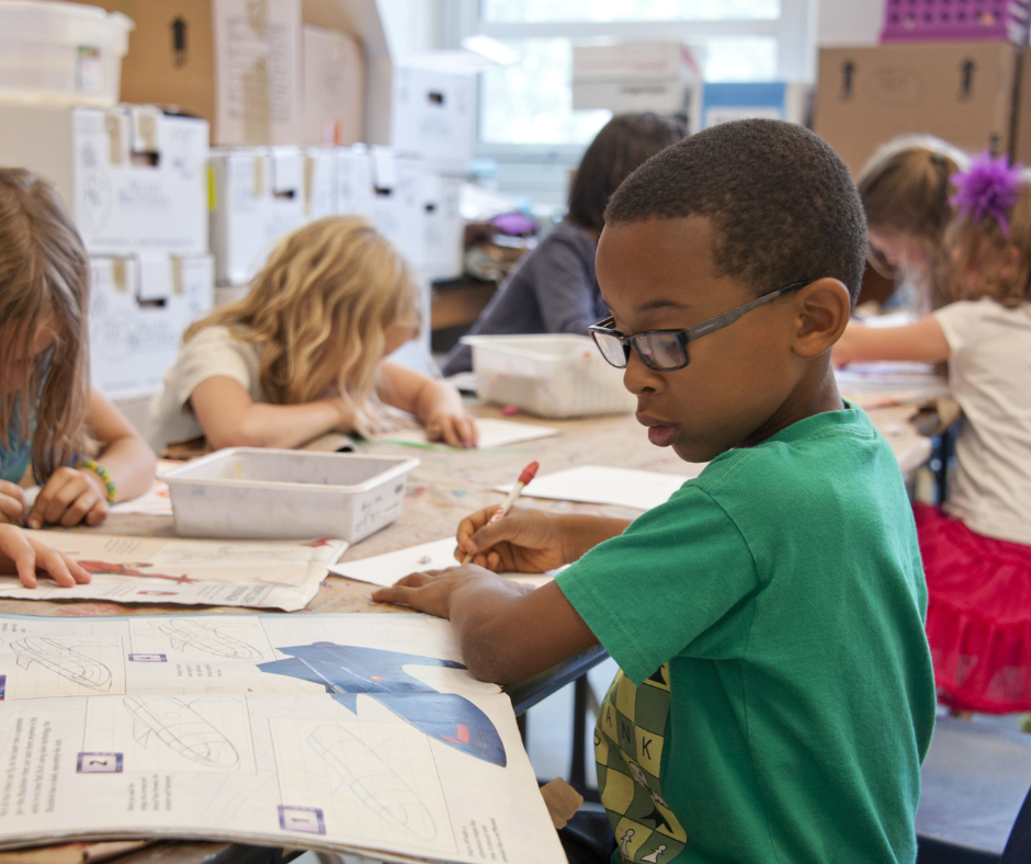 a student works at a table with other students.